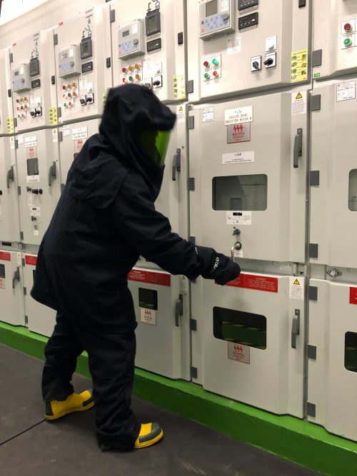 An electrical engineer in Arc Flash Protection Garments testing electrical equipment.