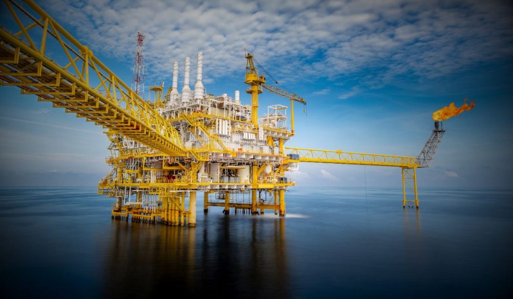 An image of an offshore oil and gas platform with the overlayed text "offshore oil & gas | electrification".